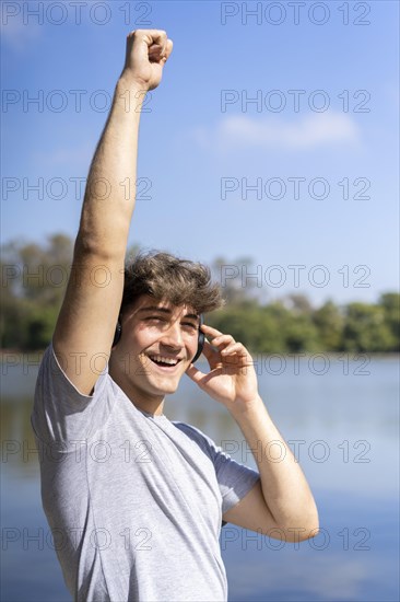 Young man listening to music outdoors with headphones. Expression of happiness