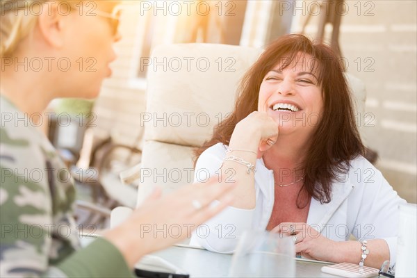 Two female friends enjoying conversation on the patio