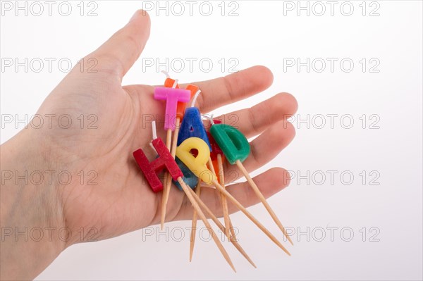 Hand holding letters made of candles on sticks