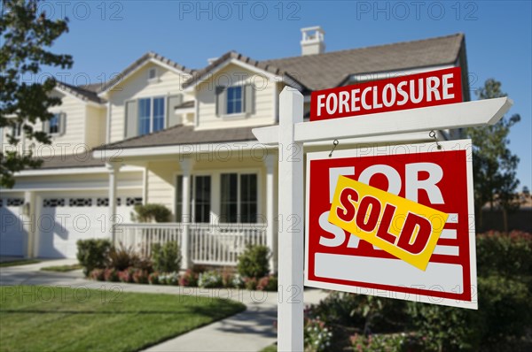 Sold foreclosure home for sale sign in front of beautiful house