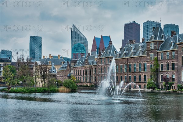 View of the Binnenhof House of Parliament and the Hofvijver lake with downtown skyscrapers in background