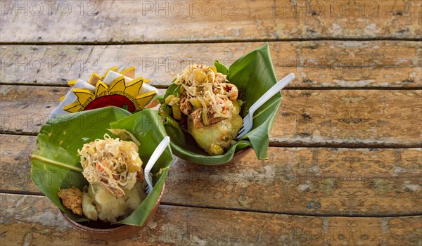 Vigoron with leaves served on a wooden table