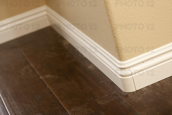 New baseboard and bull nose corners with laminate flooring abstract