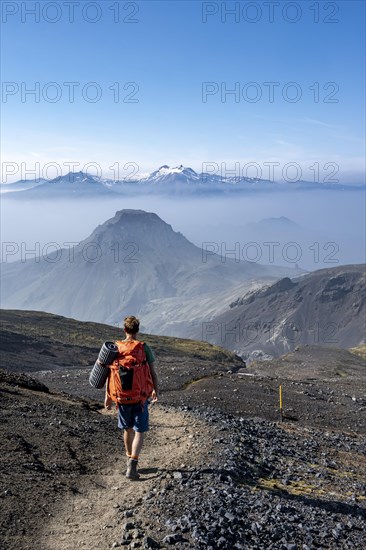 Hikers on hiking trail through volcanic landscape