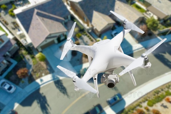 Unmanned aircraft system quadcopter drone in the air over residential neighborhood