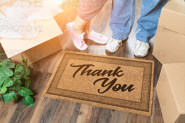 Man and woman unpacking near thank you welcome mat