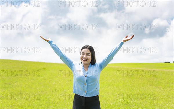 Attractive girl spreading her arms in the field