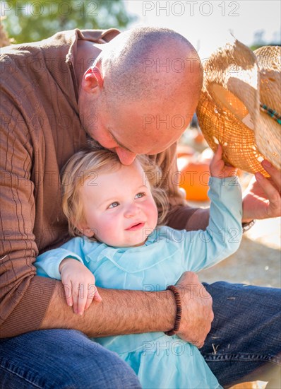 Adorable young family enjoys a day at the pumpkin patch