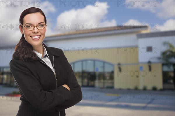 Attractive serious mixed-race woman in front of vacant commercial retail building