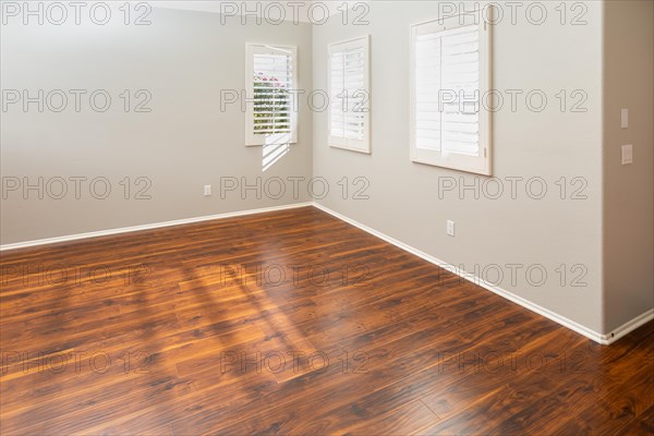 Newly installed brown laminate flooring and baseboards in home