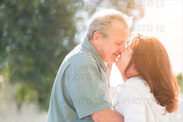 Happy middle aged couple enjoy A romantic slow dance and kiss outside