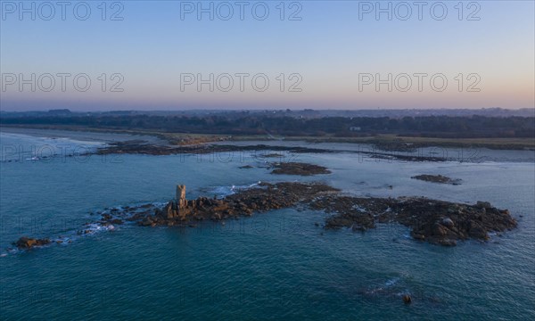 Aerial view of rock formations in the sea in front of the sandy beach Ker Emma and dunes Keremma shortly in front of sunset