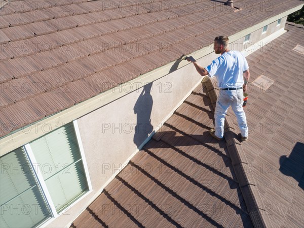 Professional painter using A brush to paint house facade