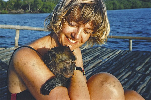 Woman holding wet baboon