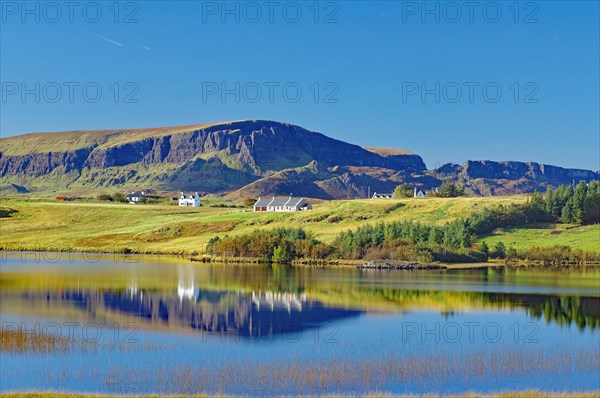 Haeuser und Berge spiegeln sich in einem seichten See