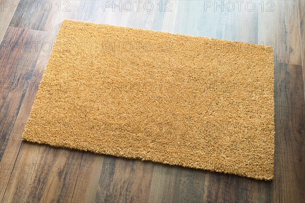 Blank welcome mat on wood floor background ready for your own text