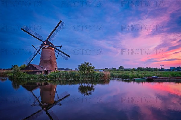 Netherlands rural landscape with windmills at famous tourist site Kinderdijk in Holland in dusk with dramatic sky