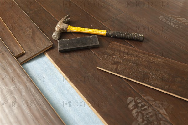 Hammer and block with new laminate flooring abstract