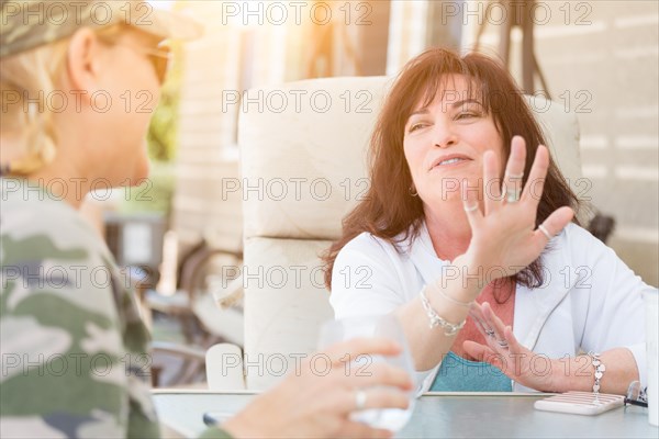 Two female friends enjoying conversation on the patio