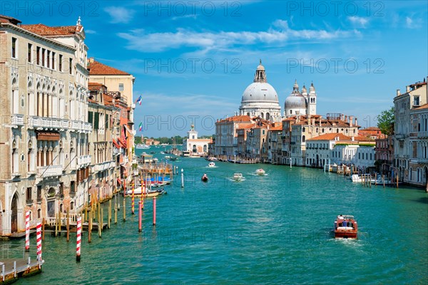 View of Venice Grand Canal with boats and Santa Maria della Salute church in the day from Ponte dell'Accademia bridge