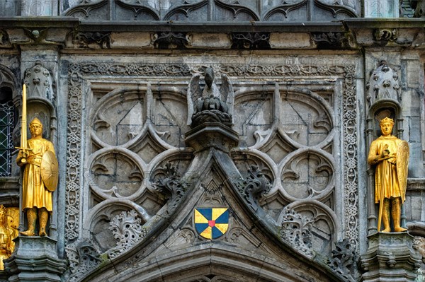 Golden statues and architectural details on the facade above the entrance of the Basilica of the Holy Blood in Bruges