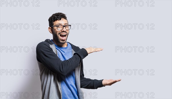 Smiling person showing an object with his palms