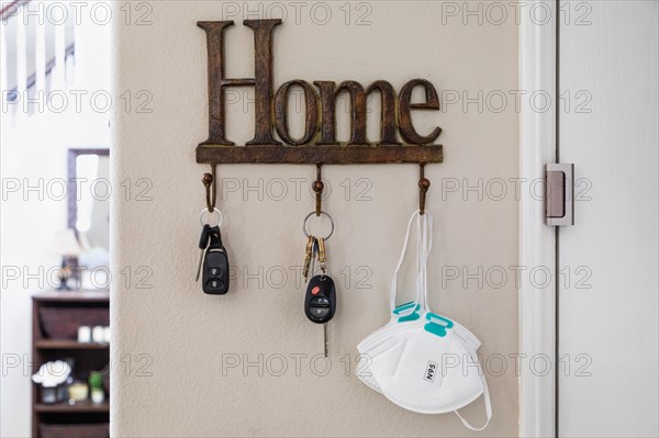 Home key hanger rack next to door with keys and medical face mask during coronavirus pandemic