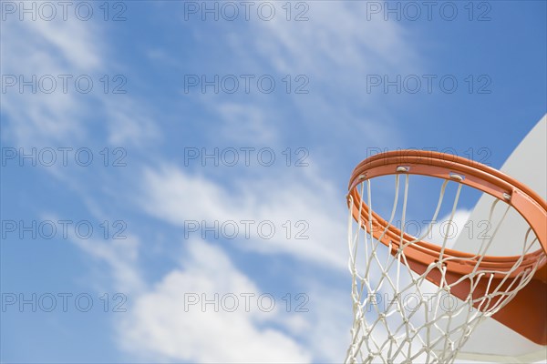 Abstract of community basketball hoop and net against blue sky