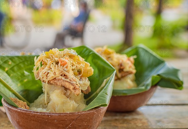 Vigoron with leaves served on a wooden table