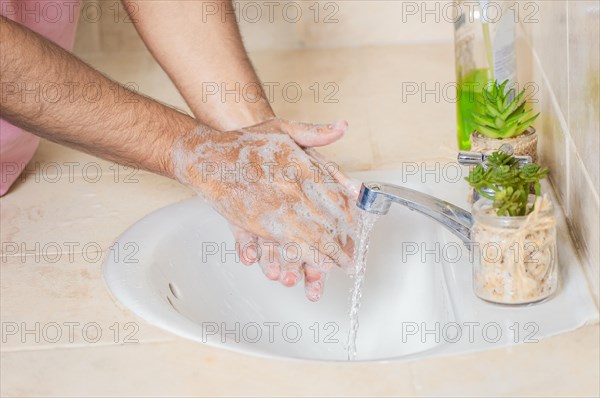 Close up of a man washing their hands with soap