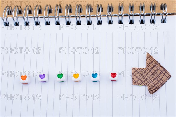 Love cubes and paper arrow on a notebook on canvas