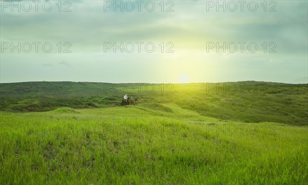 Two people riding in the field