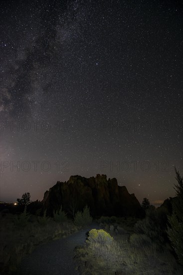 Lighted path and canyon against night sky