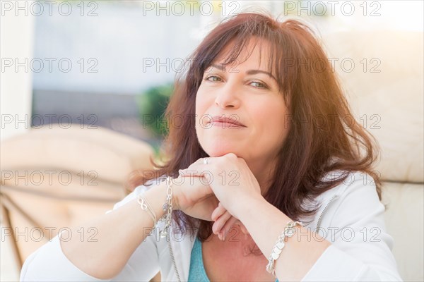 Attractive middle aged woman smiles on the patio
