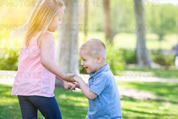 Young brother and sister playing at the park togther