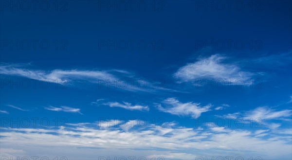 Blue clear sky with white cirrus spindrift clouds background