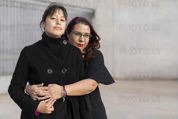 Couple of lesbian women hugging in a park. Copy space