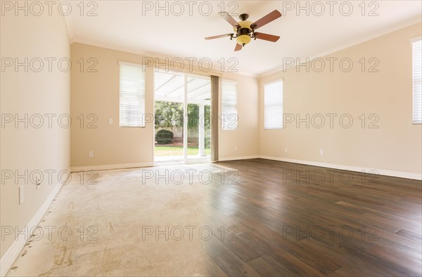 Room with gradation from cement floors to hardwood flooring installed