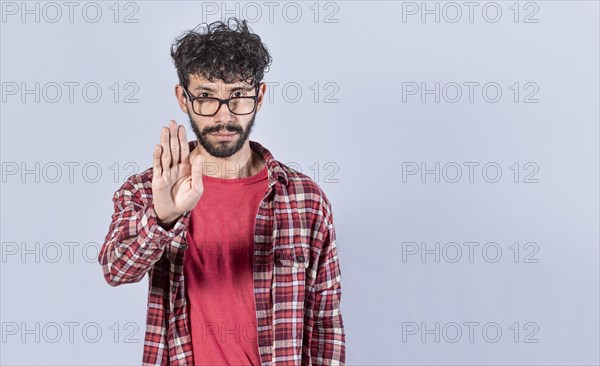 Serious young man stop sign with palm