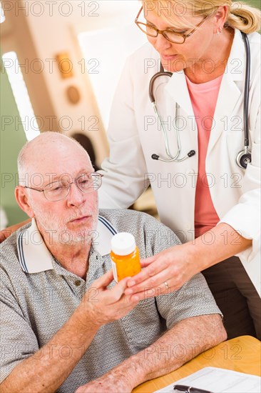 Doctor or nurse explaining prescription medicine to attentive senior man