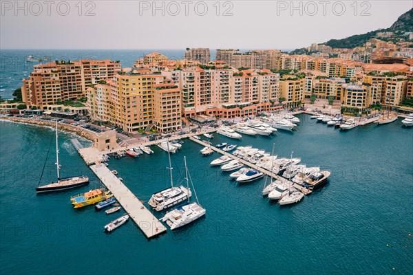 Harbor with moored yachts and boats and residential houses in Moncte Carlo
