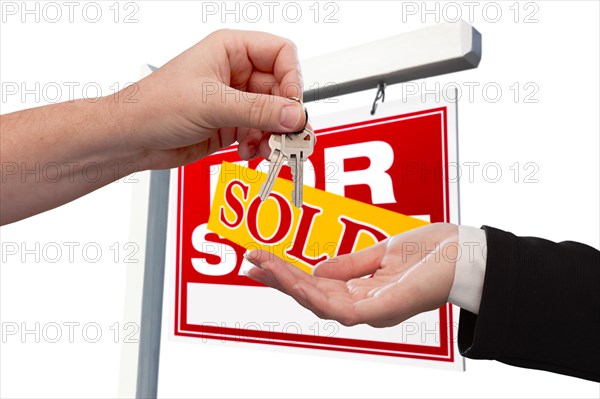 Agent handing over the key to a new home with real estate sign in the background isolated on white