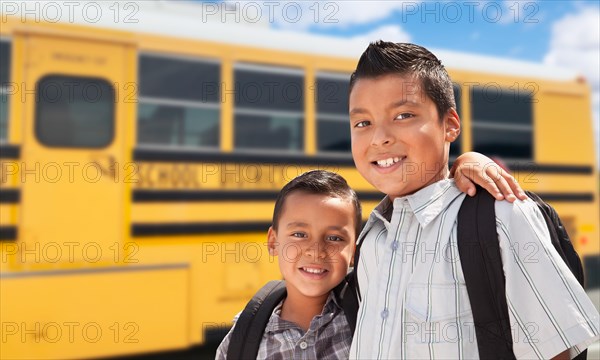 Young hispanic boys walking near school bus