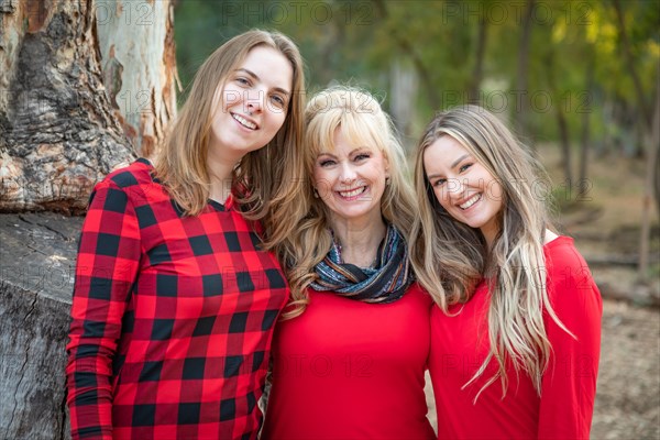 Beautiful mother and young adult daughters portrait outdoors