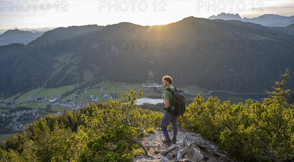 Hiker standing on hiking path between mountain pines