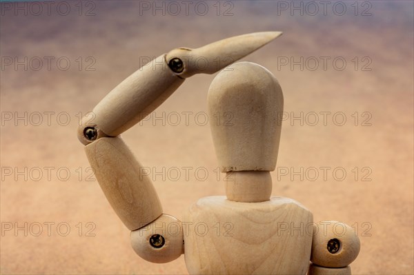 Anatomy doll making a hand gesture on a wooden background