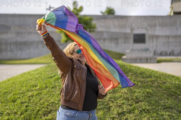 Young blonde woman holding lgbt flag. Concept of freedom and tolerance