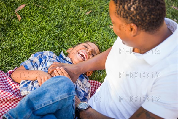 Happy african american father and mixed-race son playing at the park