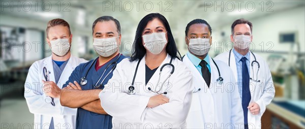 Variety of medical healthcare workers wearing medical face masks amidst the coronavirus pandemic within hospital