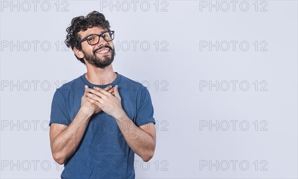 Attractive friendly and positive looking young man with a charming sincere smile feeling grateful